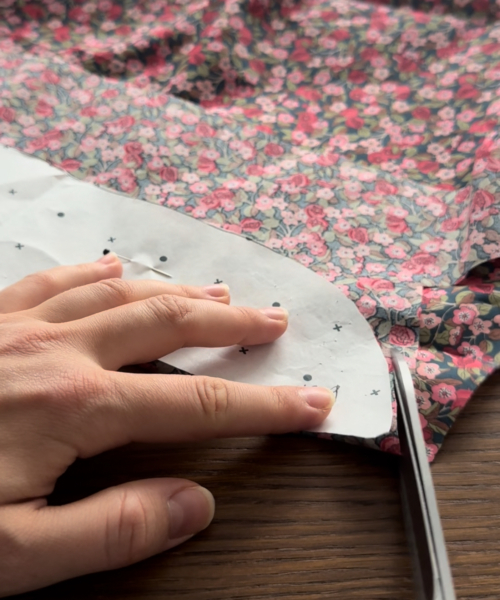 cutting fabric for the dress with scissors