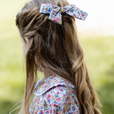 girl wearing hair bow in liberty of london print salters forest