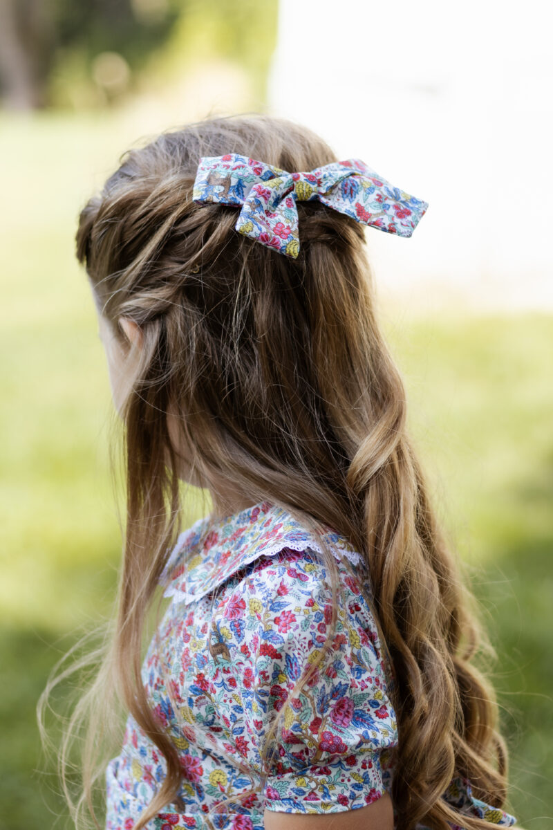 girl wearing hair bow in liberty of london print salters forest