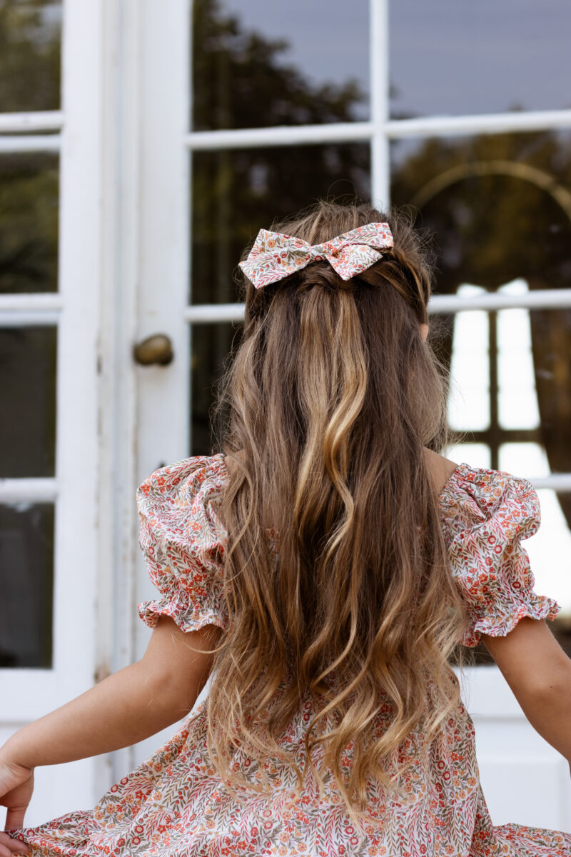 toddler girl wearing hair bow in liberty cotton naiad