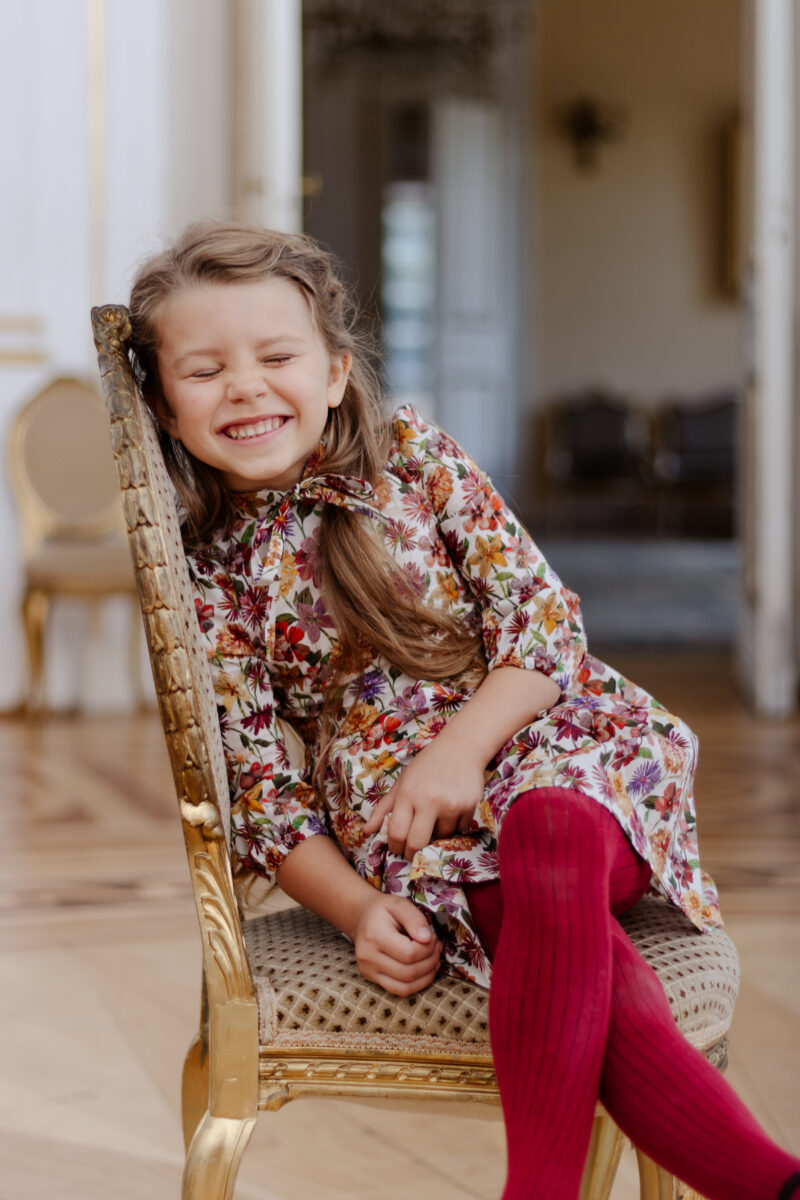 girl smiling wearing dress for fall in liberty print