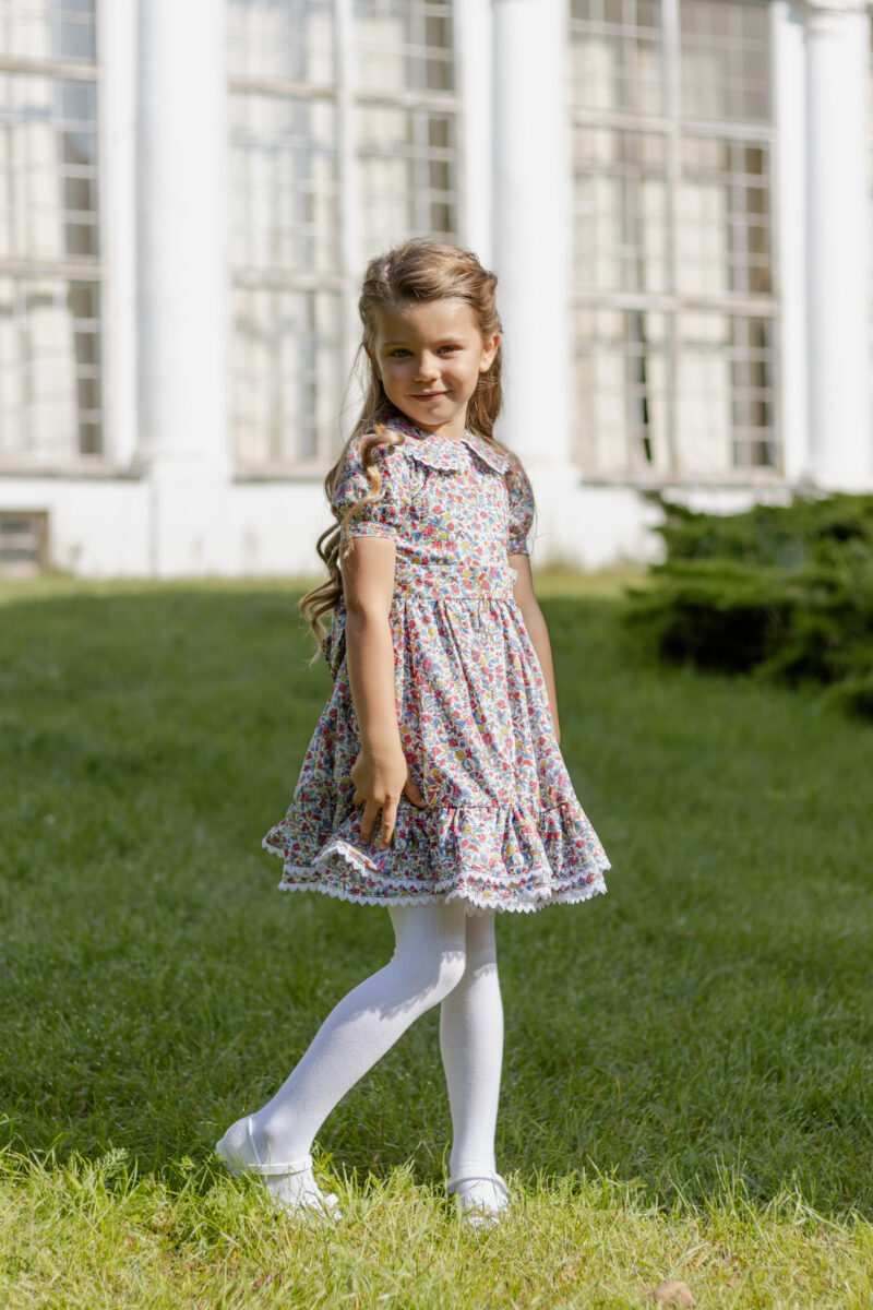 girl standing wearing dress with short bubble sleeves and collar
