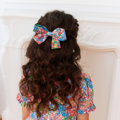 girl wearing hair bow made with liberty fabric red flowers