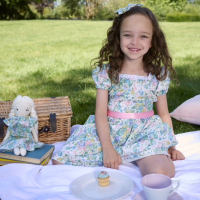 girl sitting on picnic wearing green floral dress bridgerton inspired