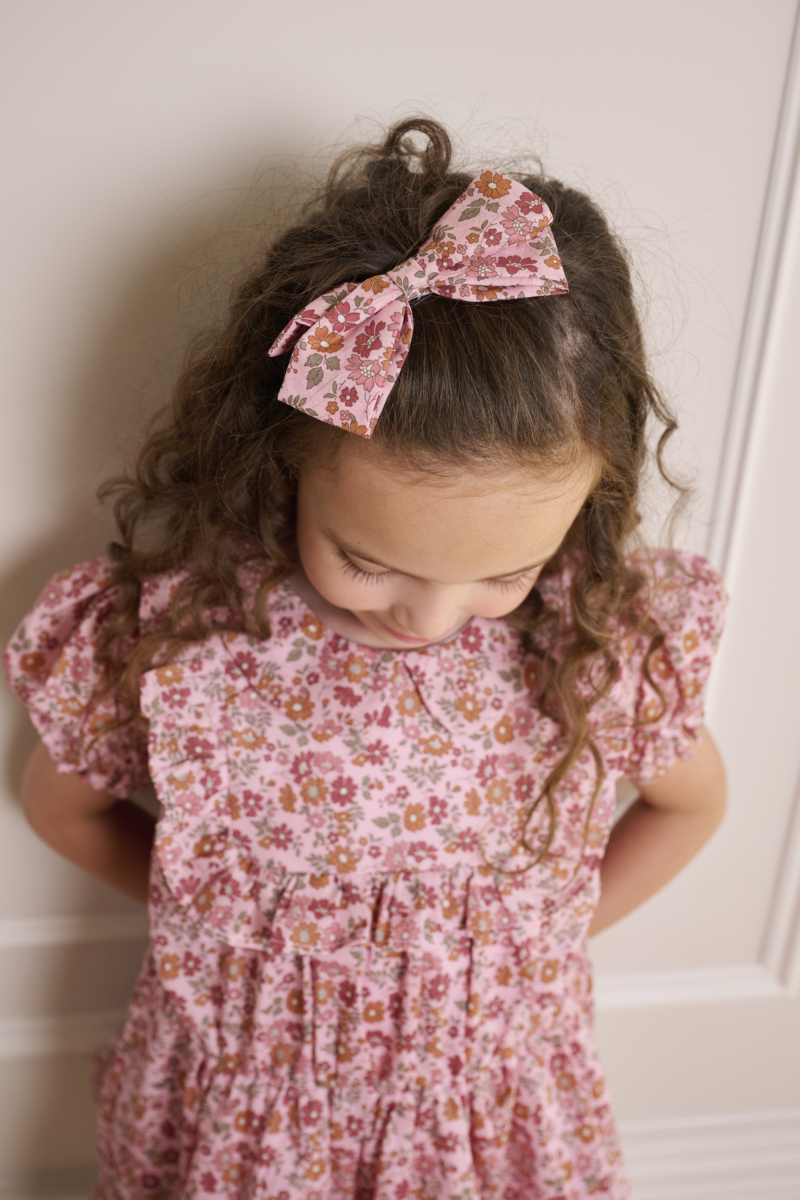 girl wearing light pink hair bow