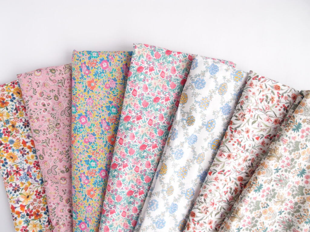 A display of different floral Liberty of London fabrics used to make the Liberty print dress.
