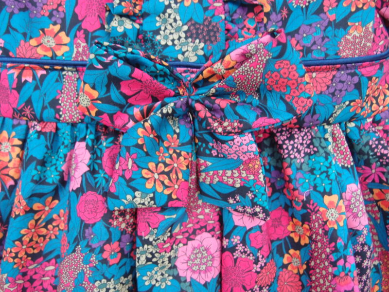 bow at the front of baby girl dress navy color pink flowers liberty fabric